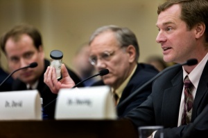 Dr. Andrew Maynard holds up a jar of nano titanium dioxide while testifying a House Science Committee hearing